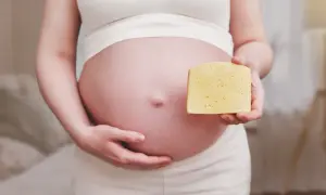 Ciężarna kobieta trzyma kawałek sera. Czy to camembert w ciąży?