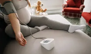 Kobieta w ciąży mierzy ciśnienie, monitorując potencjalny wysoki puls w ciąży.