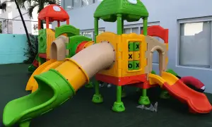 Kolorowy plac zabaw z rurami, zjeżdżalniami i elementami do gry w kółko i krzyżyk.