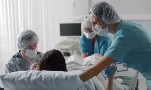 Wsparcie podczas porodu. Rodzice i personel medyczny czuwają nad kluczowymi fazami porodu, oferując pomoc i troskę.