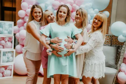 Radosne baby shower pomysły: przyszła mama otoczona przyjaciółkami, balony i dekoracje tworzą wyjątkową atmosferę.