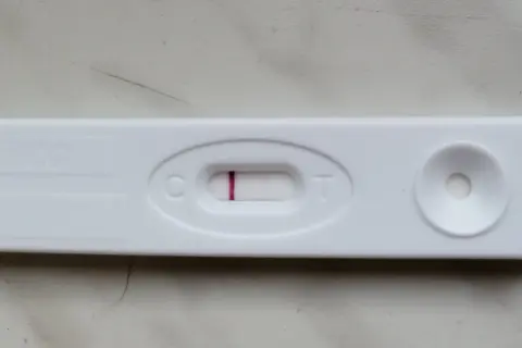 Blada kreska na teście ciążowym, widoczna przy literze "C", sugeruje wynik negatywny.