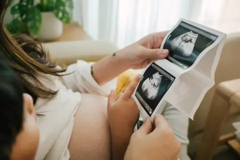 Rodzice oglądają USG. To już 11 tydzień ciąży, który to miesiąc? Dziecko rośnie.