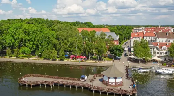 Idealne miejsce, gdzie na Mazury z dziećmi: malowniczy deptak, drewniane molo z altaną i urokliwe miasteczko nad jeziorem.