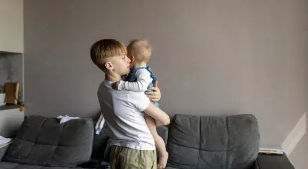 Starszy brat opiekuje się siostrą. Zastanawiasz się, od jakiego wieku dziecko może zostać samo w domu?