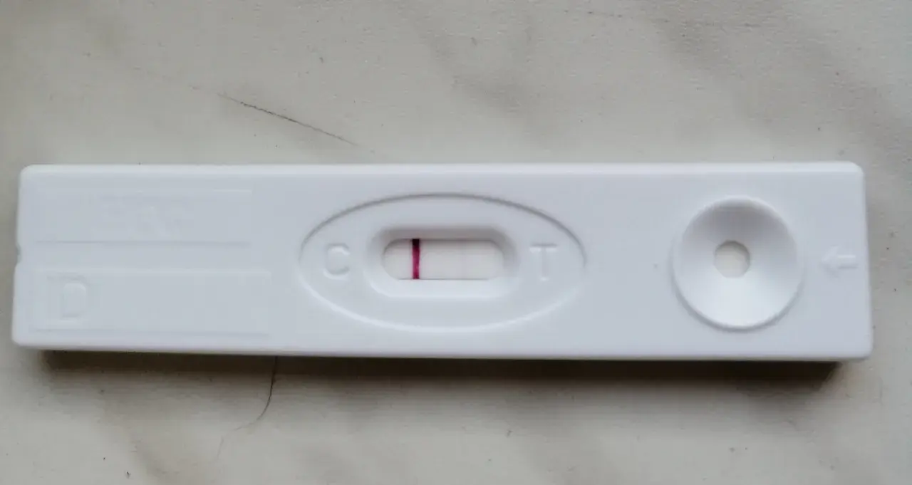 Blada kreska na teście ciążowym, widoczna przy literze "C", sugeruje wynik negatywny.