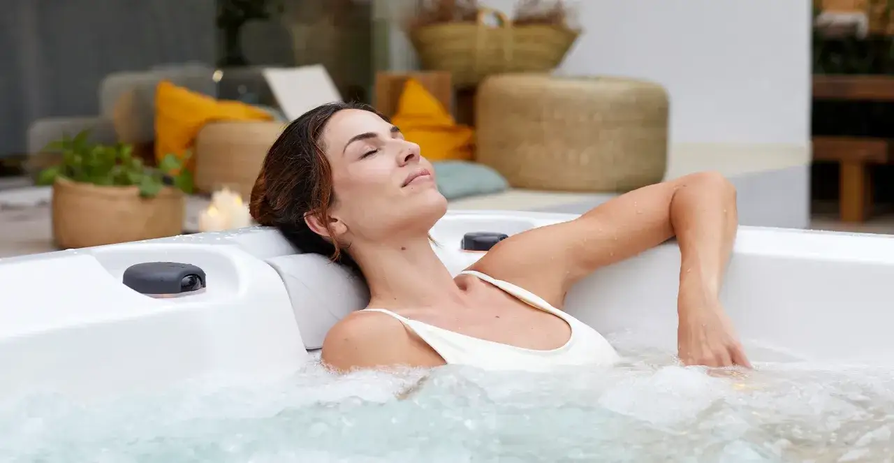 Kobieta w ciąży relaksuje się w jacuzzi, ciesząc się ciepłą wodą i bąbelkami.