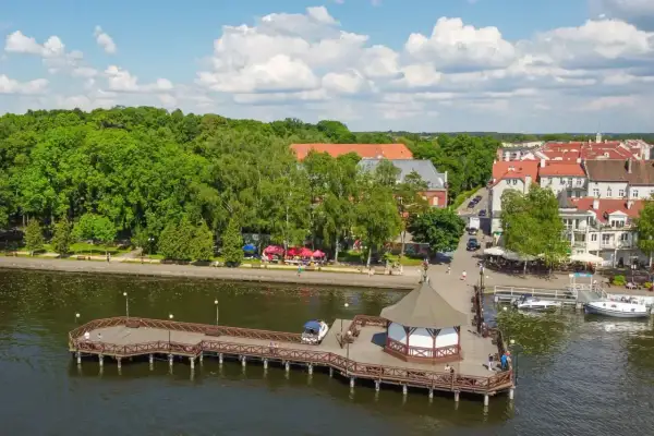 Idealne miejsce, gdzie na Mazury z dziećmi: malowniczy deptak, drewniane molo z altaną i urokliwe miasteczko nad jeziorem.
