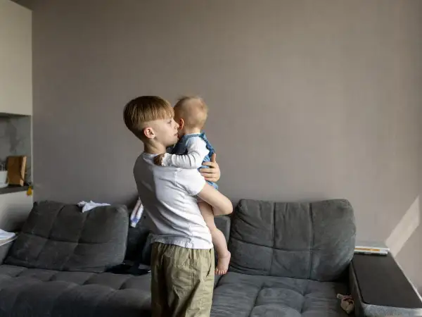 Starszy brat opiekuje się siostrą. Zastanawiasz się, od jakiego wieku dziecko może zostać samo w domu?